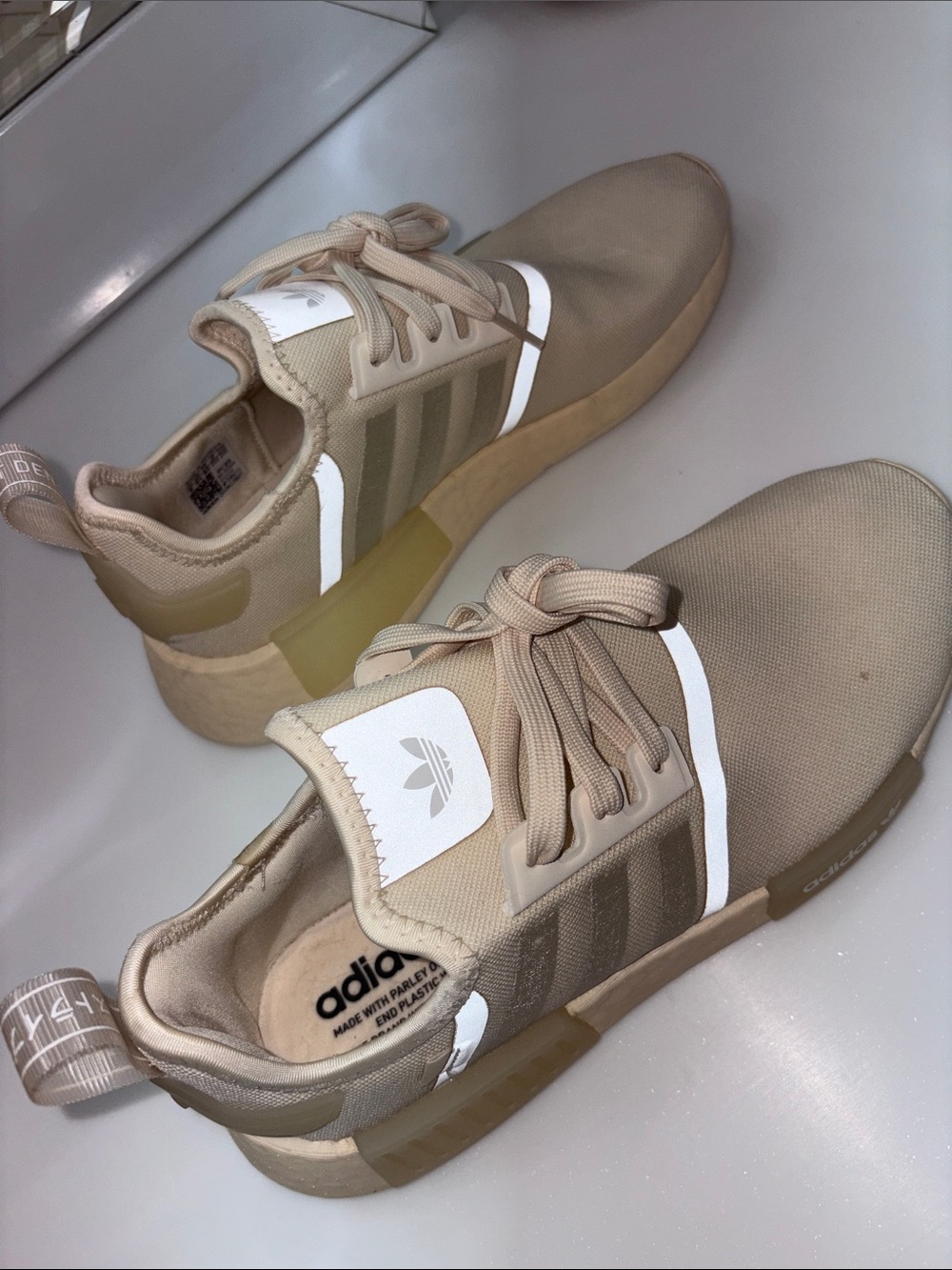 Adidas beiges running shoes with reactive light accents.